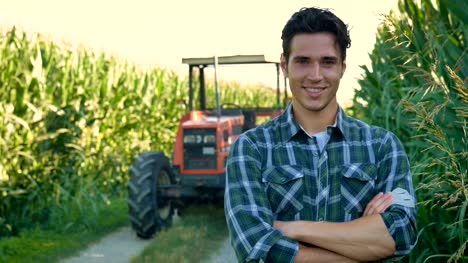 Porträt-eines-glücklichen-jungen-Landwirts-mit-frischem-Gemüse-in-einen-Korb.-Hintergrund-ein-Traktor-und-Natur-Konzept-biologischen,-Bio-Produkte,-Bio-Ökologie,-um-selbst-in-die-Hand,-Vegetarier,-Salate-gesund-gewachsen