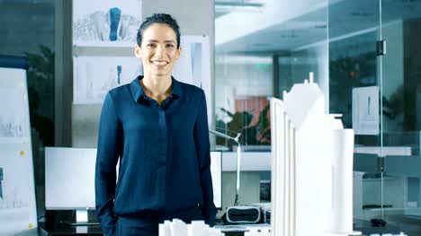 Female-Architectural-Designer-Works-on-a-Model-of-a-City-District-with-Buildings,-Parks-and-It's-Own-Ecosystem.-She-Smiles.-Beautiful-Woman-in-Bright-Minimalistic-Office.