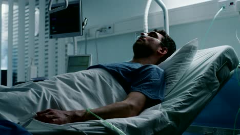 En-el-Hospital,-enfermo-terminal-sufre-mientras-se-está-acostado-en-la-cama.-Hombre-joven-en-sala-de-cuidados-paliativos.