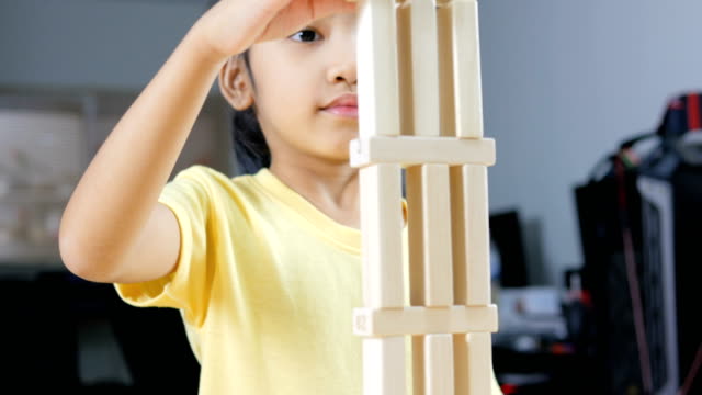 Close-up-shot-Asian-little-girl-playing-wooden-brick-toy