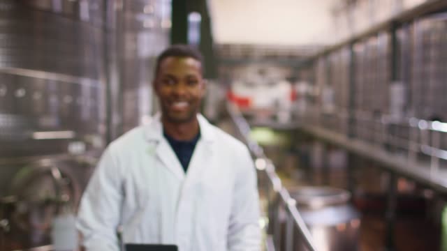 Junger-schwarzer-Mann-arbeiten-bei-einer-weinfabrik-zu-Fuß-in-den-Fokus