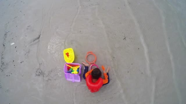 Kinder-spielen-Spielzeug-am-Strand.-Ansicht-von-oben