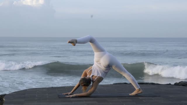 Woman-Doing-Standing-Split-Pose-on-Coastline