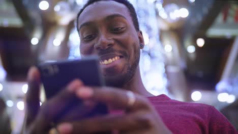 Hombre-afroamericano-usando-business-app-en-el-teléfono-inteligente