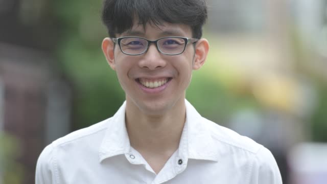 Junge-glücklich-asiatischen-Geschäftsmann-lächelnd-in-den-Straßen-im-freien
