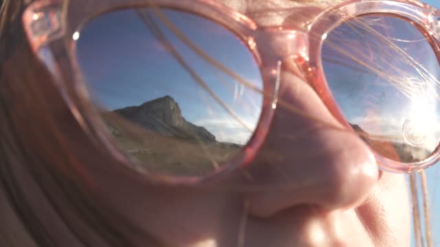 Himmel-und-Berge-spiegeln-sich-in-den-Gläsern-eines-jungen-Mädchens