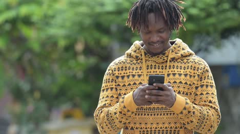 Schönen-jungen-afrikanischen-Mann-mit-Handy-in-den-Straßen-im-freien