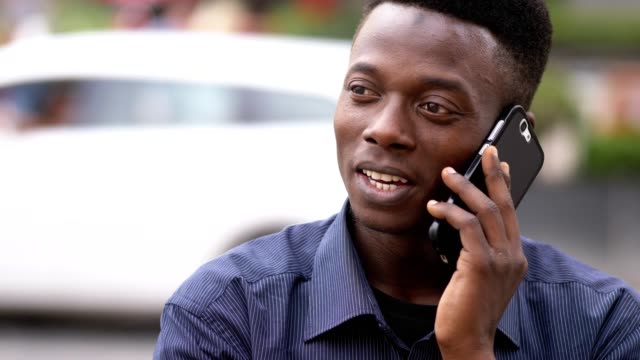 Relaxed-junge-Afrikaner-durch-Telefon-Outdoor-hautnah
