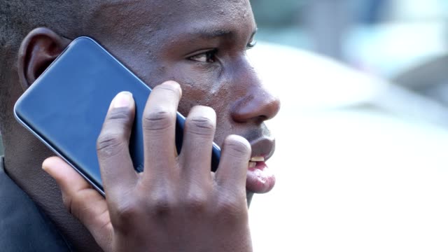 Junge-afrikanische-Amerikaner-sprechen-per-Telefon-in-der-Straße