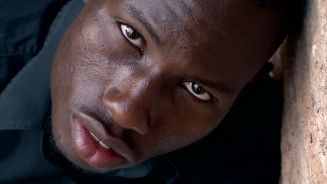 Sad-scared-young-black-man-staring-at-camera--top-view