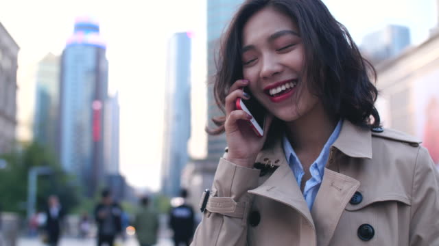 Ziemlich-glücklich-junge-Asiatin-telefonieren-mit-dem-Handy