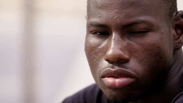 close-up-portrait-of-Thoughtful-proud-youn-black-african-man-staring-at-camera,closing-his-eyes