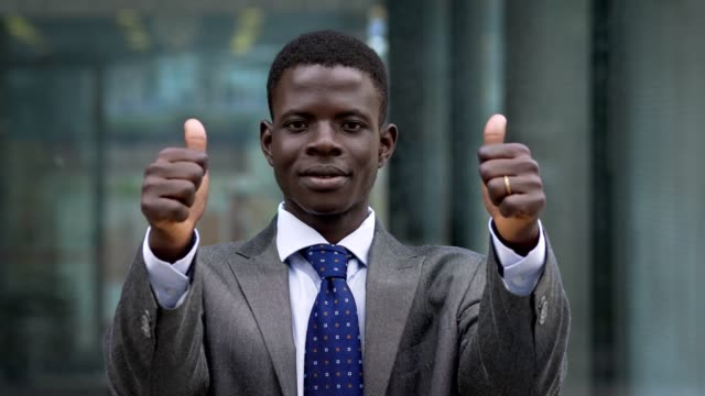 Success,winning.-Young-american-african-man-making-thumbs-up--outdoor