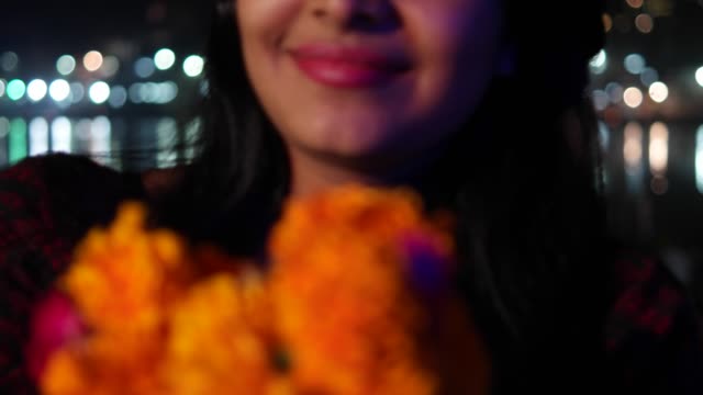 Beautiful-young-woman-hands-joined-in-namaste-greets-with-orange-marigold-flower-garland-on-her-neck-offers-prayers-worship-God-Goddess-hands-welcomes-smiles-glowing-respect-believer-religion-handheld