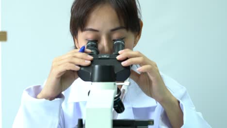 Female-scientists-looking-through-microscope-and-observe-in-modern-laboratory-or-medical-center.-Concept-of-science,-testing-development-and-lab-industry.