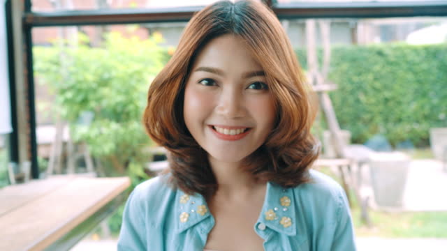 Porträt-von-schöne-junge-asiatische-Brünette-Frau-lächelnd,-während-Sie-im-Café-stehen.-Frauen-Lifestyle-Konzept.