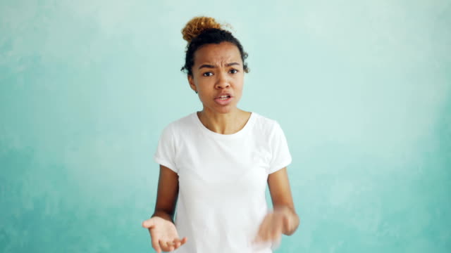 Portrait-of-screaming-mixed-race-woman-talking-and-gesturing-expressing-negative-emotions-then-walking-away-angry-and-offended.-Feelings-and-people-concept.