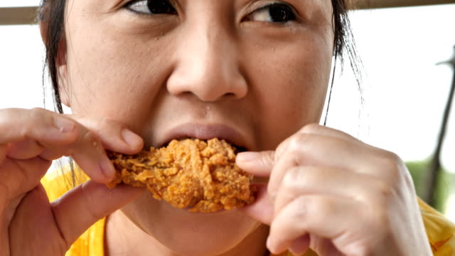Linda-mujer-asiática-de-primer-plano-son-felices-comiendo-pollo-frito-en-el-restaurante.-Video-4k-lenta