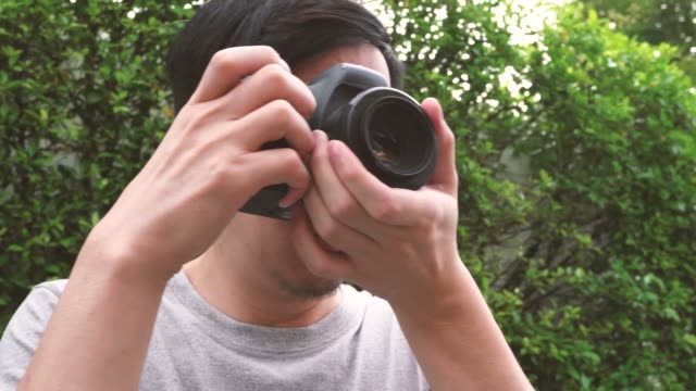 Orbit-circle-shot-of-young-male-photographer-taking-photos-in-nature-scenery