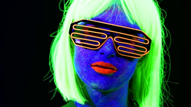 Woman-with-UV-face-paint,-wig,-UV-glasses,-glowing-clothing-portrait,-face-close-up-of-make-up.-Caucasian-woman.-.