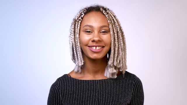 Young-African-girl-with-dreadlocks-smiling,-laughing-and-looking-at-camera,-White-background