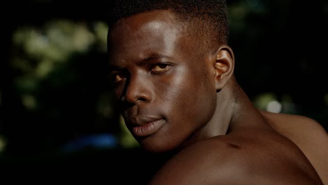 Hombre-africano-sin-camisa-negro-enojado-girando-y-mirando-a-cámara