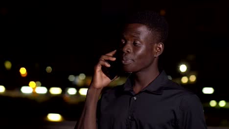 hombre-africano-americano-hablando-por-teléfono-en-la-ciudad-de-noche-tecnología,-comunicación