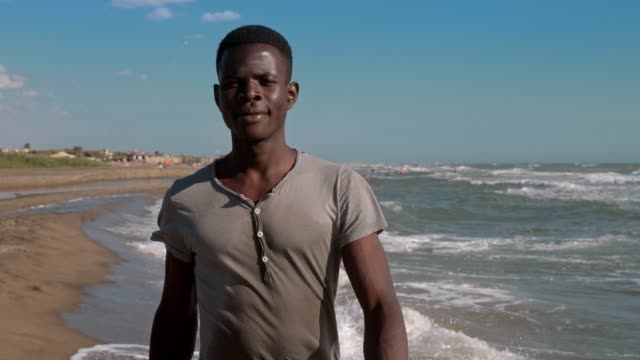 Confident-proud-handsome-blac-african-man-walking-on-the-beach--slow-motion