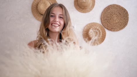 portrait-healthy-young-woman-free-of-allergies-with-bouquet-of-feather-grasses-laughing-and-looking-in-camera