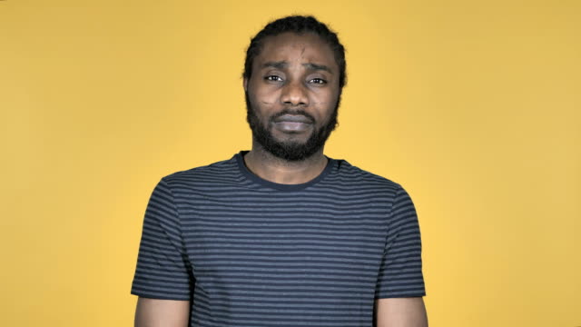 Legerer-afrikanischen-Mann,-Blick-in-die-Kamera-auf-gelbem-Hintergrund-isoliert
