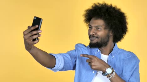 Afro-amerikanischer-Mann-unter-Selfie-mit-Smartphone-auf-gelbem-Hintergrund