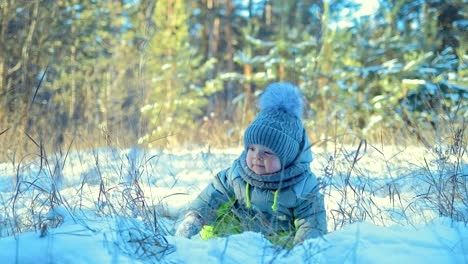 Niño-está-sentado-en-la-nieve.-Bebé-está-mirando-a-su-alrededor.-Día-de-invierno