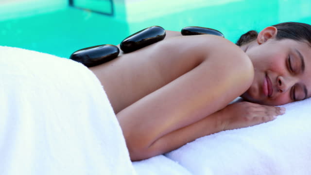 Friedliche-brunette-immer-hot-stone-massage-am-Pool