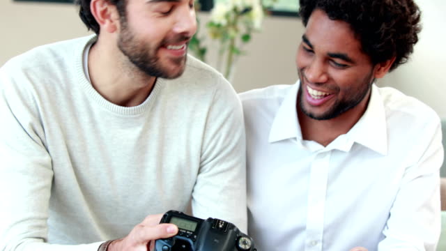 Gay-couple-looking-pictures-together-on-their-camera