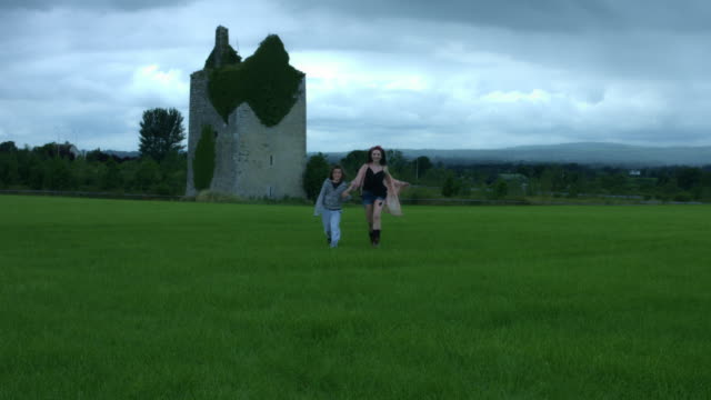 4k-Castle-in-Background-Shot-of-a-Woman-and-her-Son-running