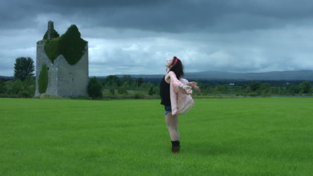 4k-Castle-in-Background-Shot-of-a-Woman-in-Wind