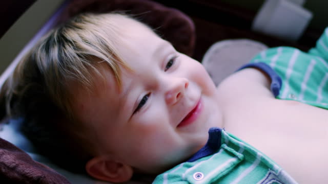 Adorable-baby-boy-in-pajamas-laying-on-a-changing-table,-looking-up