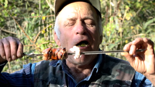 An-elderly-man-eating-fried-meat