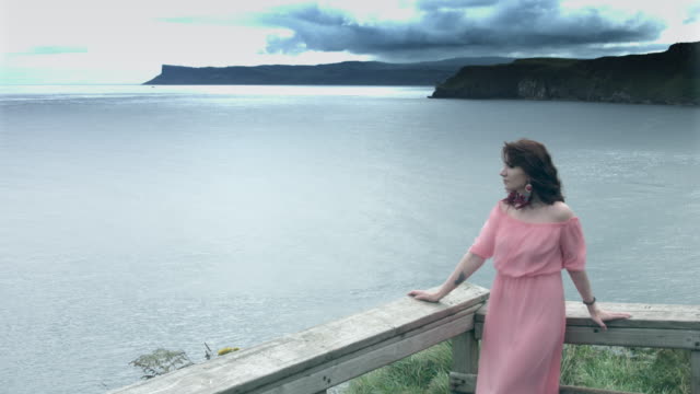 4k-la-foto-de-una-mujer-posando-en-una-trayectoria-de-costa-y-mar