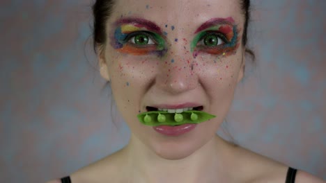 4k-schoss-einer-Frau-mit-bunten-Make-up-mit-Bohnen-in-Mund