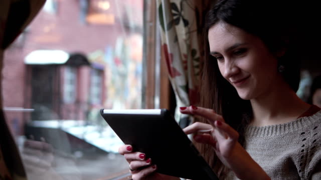 Schöne-junge-Mädchen-mit-Tablet-Computer-Touchscreen-im-café