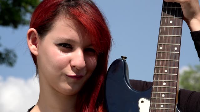 Mujer-pelirroja-posando-con-guitarra