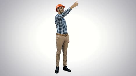 Lächelnde-Bauarbeiter-mit-Telefon,-um-Selfies-auf-weißem-Hintergrund-zu-nehmen