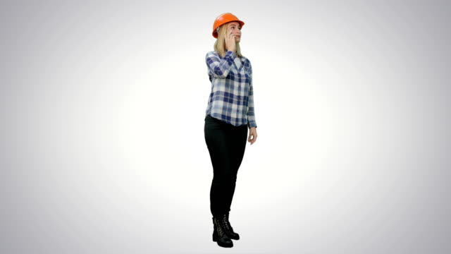 Beautiful-female-engineer-in-hardhat-havin-a-phone-call-correcting-the-project-on-white-background
