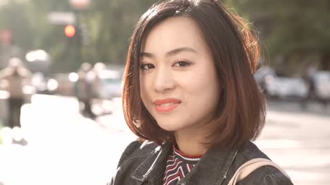 süße-und-ruhige-asiatische-Frau-auf-der-Straße,-süß-lächelnd-in-die-Kamera