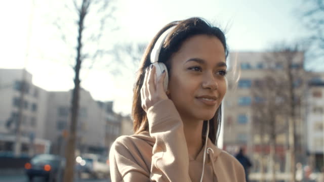 Young-woman-with-headphones-enjoying-time-in-a-city.