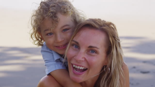 Portrait-of-mother-and-young-son-at-beach.