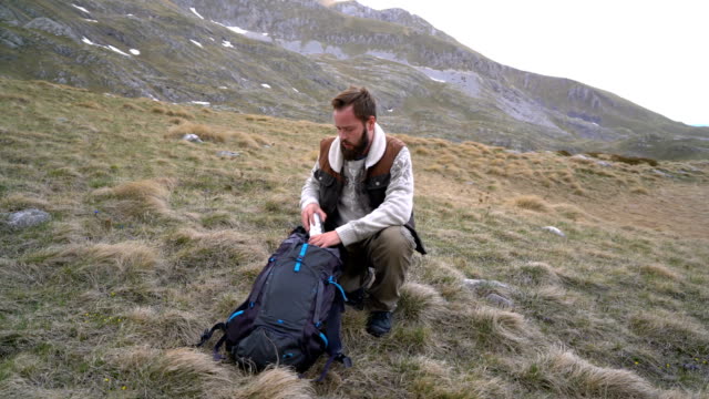 Hiker-sits-and-drinks-hot-tea-from-a-thermos