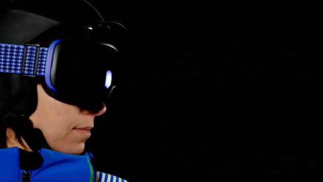 Retrato-de-media-cara-de-mujer-de-esquiador/snowboarder-con-gafas-en-fondo-negro