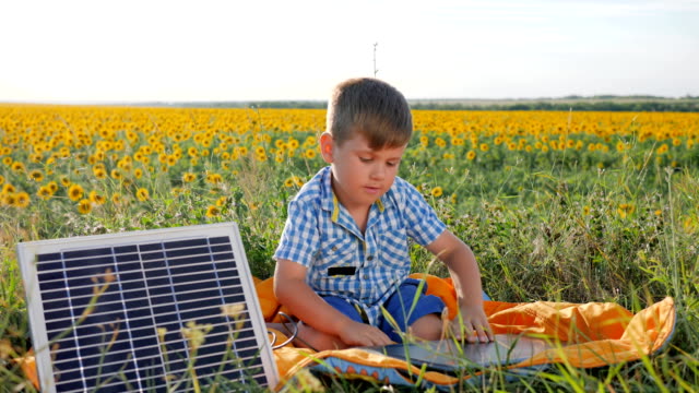 environmentally-friendly,-child-shows-hand-gesture-like-near-solar-photovoltaic-panels-on-background-field,-boy-uses-solar-energy
